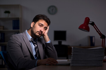 Young male employee working late in the office