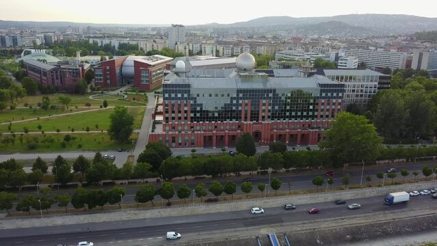Cinematic 4K aerial drone orbit shot of L&aacute;gym&aacute;nyosi ELTE Campus Southern Block, University of Technology and Economics, Kopaszi-g&aacute;t by the Danube river in Budapest, Hungary