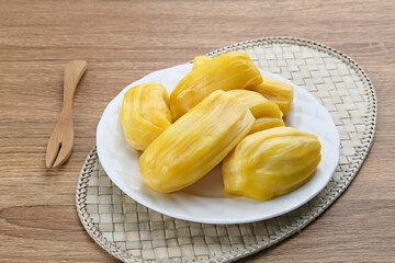 Fresh and ripe jackfruit served on a plate on a wooden table. Space for text.
