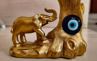 A vastu Blue devil eye along with an elephant in gold colour on fang sui item