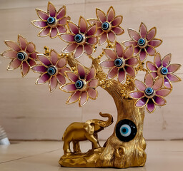 A vastu Blue devil eye along with an elephant and 10 vastu devil eye flowers in gold colour on fang sui item