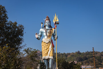 hindu god shiva statue with bright blue sky background at morning from different angle