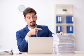 Young male employee and too much work in the office