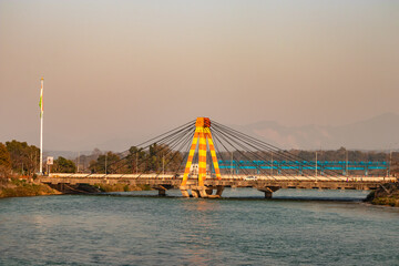 isolated cable bridge over ganges river with colorful sky at evening