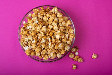 popcorn in a bowl on a pink background