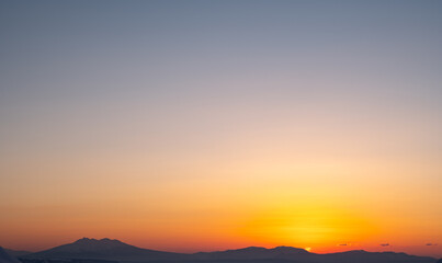 山並みのシルエットと美しいグラデーションの空。