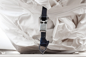 The weight belt is fastened to the deck with a ratchet lock and holds the load wrapped in a white...