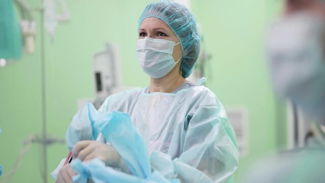 Portrait of a doctor during surgery. A professional surgeon in a medical uniform performing an operation using surgical instruments