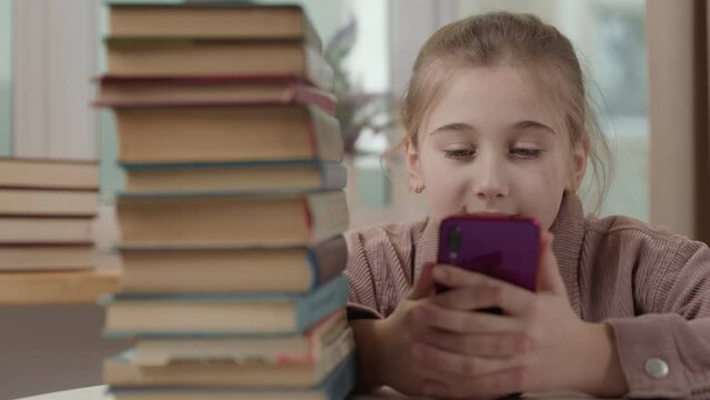 girl with a phone in her hands near a stack of books