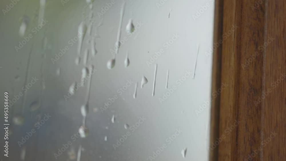 Aufkleber slow motion of water on a window while it's raining in the background
