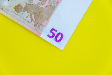 Euro money on a yellow background (copy space).