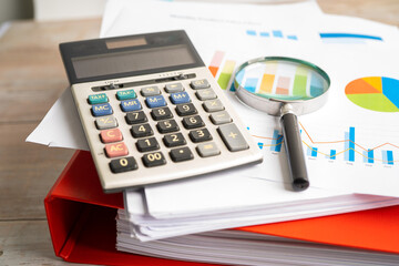 Magnifying glass and calculator on charts graphs paper. Financial development, Banking Account, Statistics, Investment Analytic research data economy, Stock exchange trading, Business office concept.