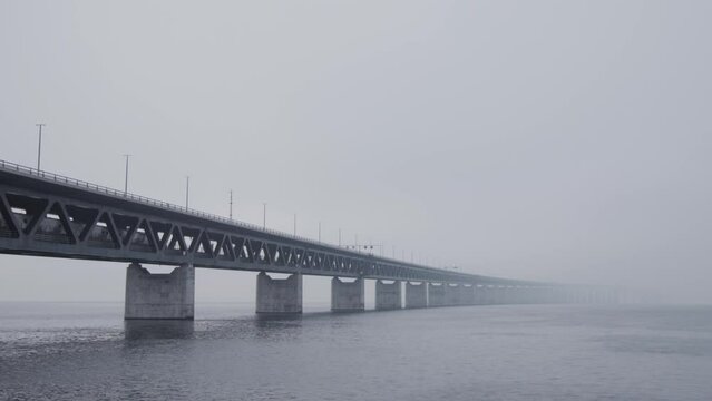 Train passing by on the Oresund bridge between Sweden and Denmark on a foggy day.