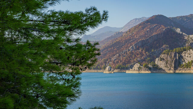 View from the slope to Oymapinar Dam through tree branches in Turkey