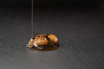 Almonds with honey on slate background