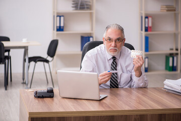 Obraz premium Aged male employee suffering at workplace