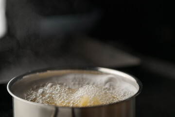 Farfalle pasta in hot boiling water in saucepan closeup
