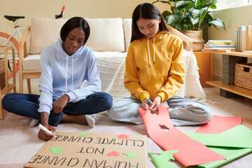 Female activists making placard for protest against climate change