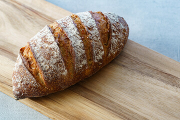 グレーのテーブルの上に置かれたパンとカッティングボード