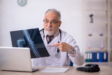 Old male doctor radiologist working at the hospital
