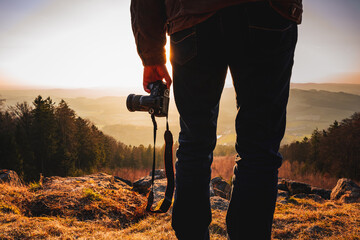 Photographer with camera in sunset taking photos of landscape. Travel Lifestyle hobby concept...