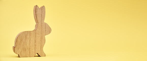 Wooden rabbit on yellow background with copy space, Happy Easter banner