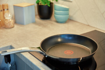 Steel frying pan in the kitchen on electric induction hob, Modern kitchen appliance