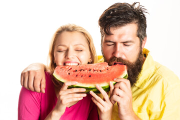 Portrait of happy couple enjoying watermelon. Cheerful couple holding slices of watermelon. Funny face. Cheerful couple holding slices of watermelon.