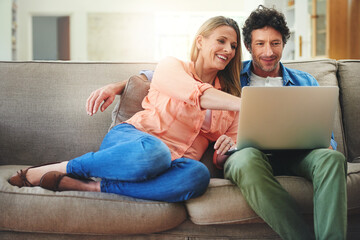 Sofa movie dates are the best. Shot of a happy mature couple using a laptop together on the sofa at home.