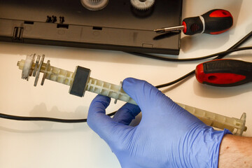 The master repairs the pickup roller on the string printer. Close-up photo of the work