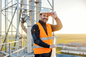An industry worker on height smiling at the camera.