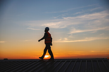 A construction worker walking on the roof of the building.