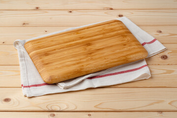 Cutting board with cotton napkin on wooden table