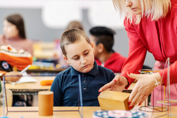 A teacher teaching pupil of shapes and geometry on math class.