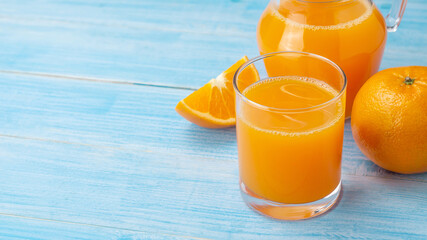 Fresh orange juice on a blue wooden table.