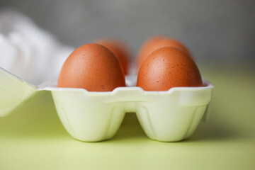 Brown eggs in expanded polystyrene packaging on an isolated light yellow background