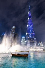 Fototapete Burj Khalifa Traditionelles Boot und Beleuchtung des Burj Khalifa mit Springbrunnenshow in Dubai