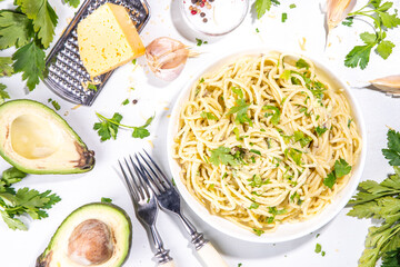 Spaghetti pasta with creamy cheese avocado pesto sauce. Healthy italian styled vegan vegetable guacamole pasta. Mediterranean food