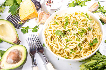 Spaghetti pasta with creamy cheese avocado pesto sauce. Healthy italian styled vegan vegetable guacamole pasta. Mediterranean food