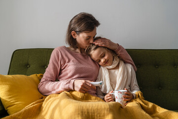 Mother embracing sick daughter at home