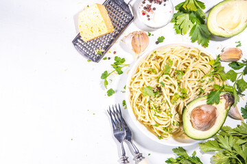 Spaghetti pasta with creamy cheese avocado pesto sauce. Healthy italian styled vegan vegetable...