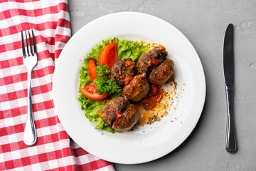 Cooked meat with fresh vegetable salad on a white plate