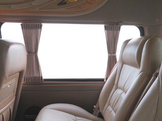 Empty brown leather seats in van over white background.