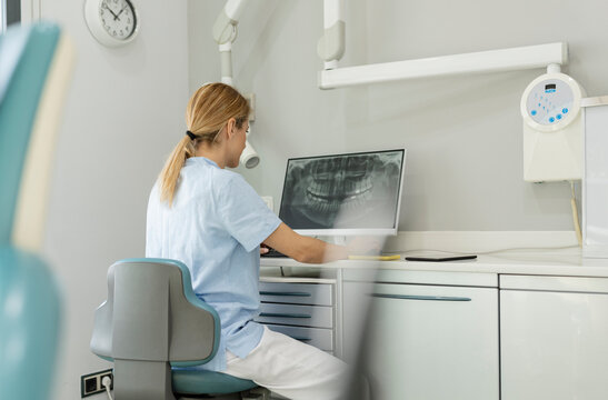 Dentist examining x-ray image on computer desktop at dental clinic