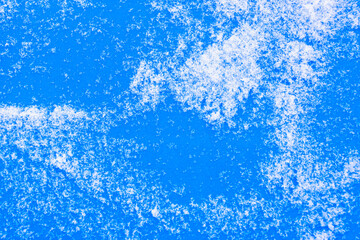 Blue background with white snow grains (copy space).