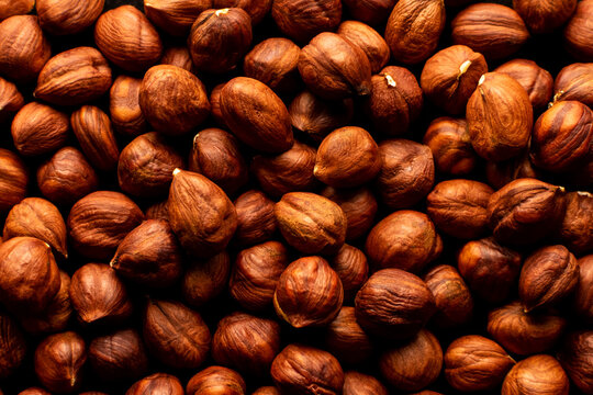 Peeled hazelnuts on a white wooden background. Isolate.