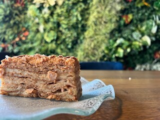 Napoleon cake on a wooden table against a background of foliage there is a place. High quality photo