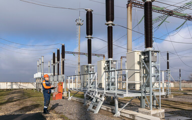 A power engineer inspects substation equipment. Energy. Industry