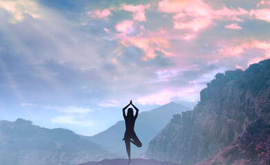 Yoga in nature. Silhouette of woman practice yoga meditation exercise outdoor. Young female sitting on mountains for relaxed yoga posture in the morning, mental health care, relaxation, meditation.