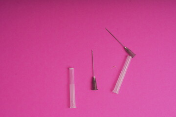 Medical syringe on a pink background. A syringe for injection. The concept of health and beauty